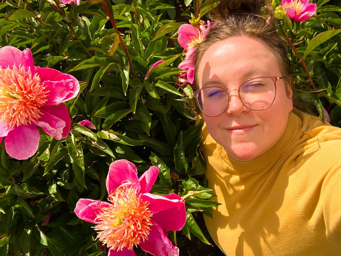 Christina Kelli Ping surrounded by beautiful pink flowers